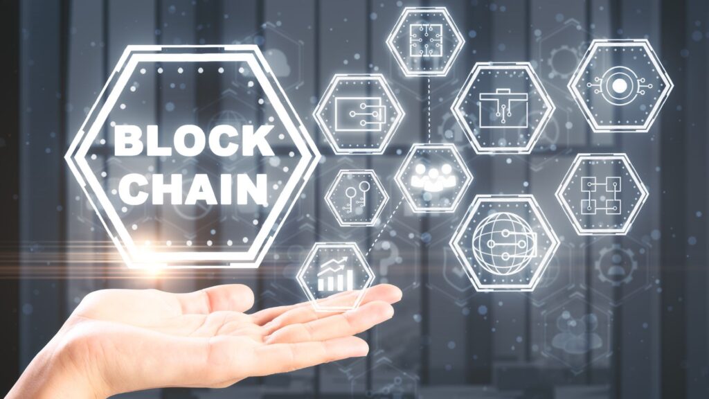 A hand holds digital blockchain graphics with engaging visuals and hexagonal icons representing technology and data concepts on a blurred background.