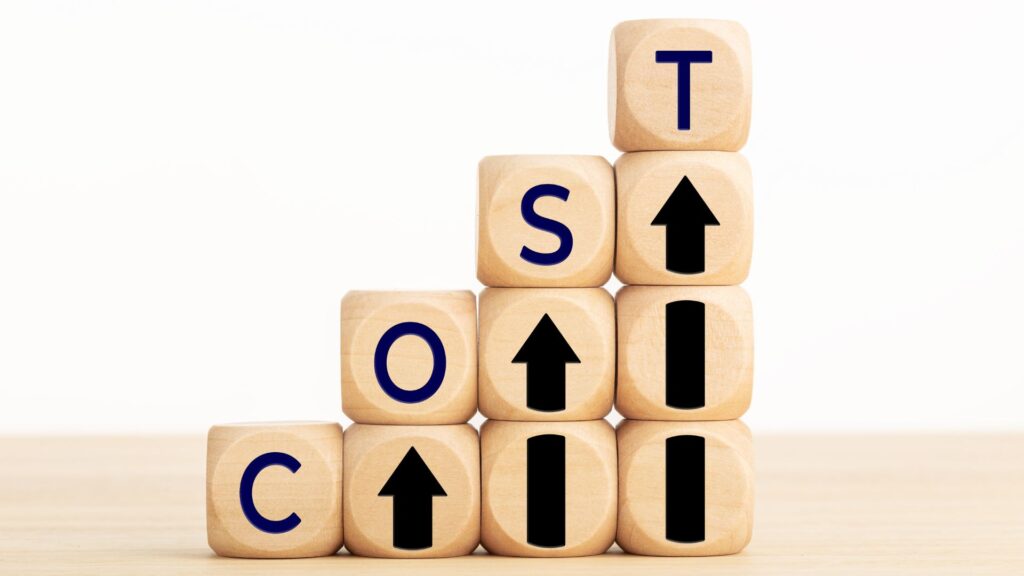 Wooden blocks arranged in steps spell out "COST" with black arrows pointing upward, visually symbolizing rising costs—a compelling image for Small Business Animation Services to illustrate financial challenges.